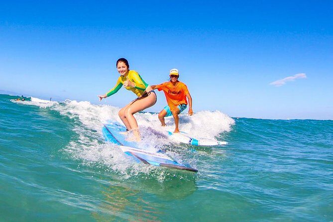 Surfing Lessons On Waikiki Beach - In the water with an instructor beside you: small group coaching that builds rides